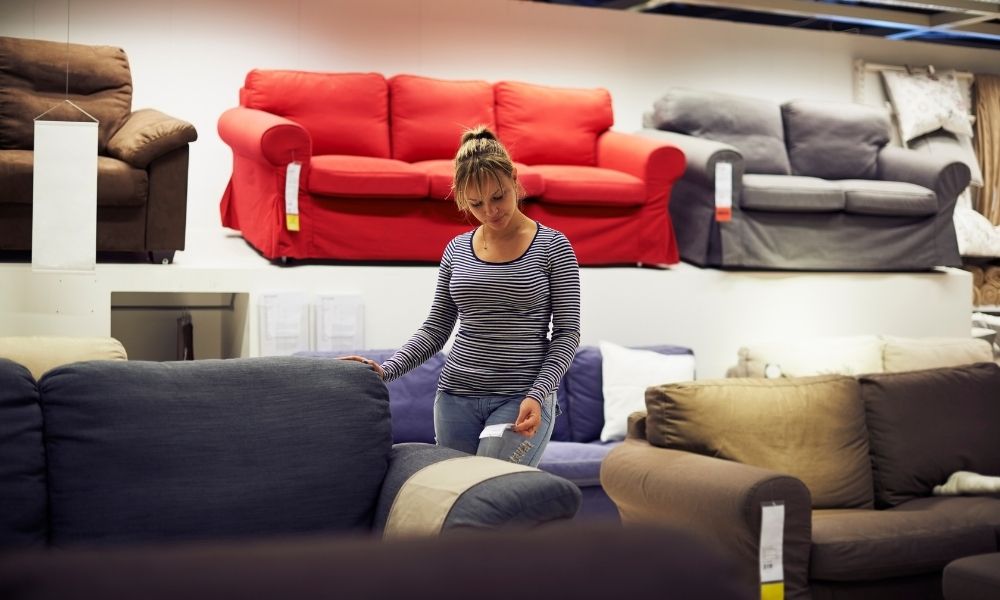 A lady is reading price tag of sofa